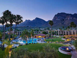 Evening view of El Conquistador Tucson, A Hilton Resort, set against the mountains.